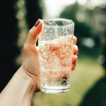 Woman's hand holds a glass of water