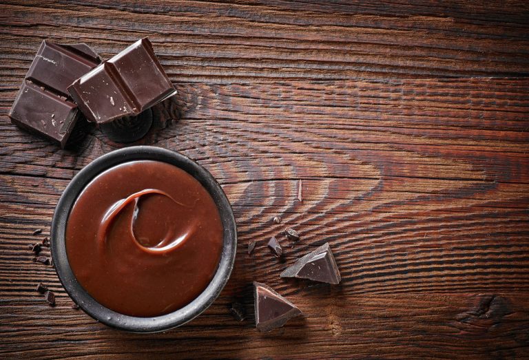 47855364 - chocolate cream and chocolate pieces on wooden table, top view